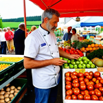 **Prompt:** A vibrant farmer's market scene in Germany, overflowing with fresh, seasonal produce. Focus on ripe tomatoes, colorful vegetables, and herbs. In the background, a chef and an individual are discussing ingredients with a local farmer, emphasizing sustainability and regional sourcing. The overall atmosphere should be bright and inviting, showcasing the quality and freshness of the local ingredients.
